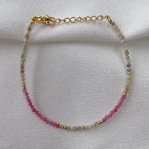 Macro detail of natural pink and grey stone beaded bracelet with 18K gold plated clasp