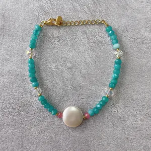 Detail view of handmade beaded bracelet with blue faceted stones and gold lobster clasp