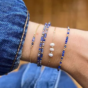 Five-piece stackable bracelet set with blue lapis beads, freshwater pearls, and gold chains