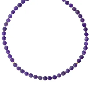 Collier artisanal en pierres naturelles violettes avec accents dorés sur fond blanc