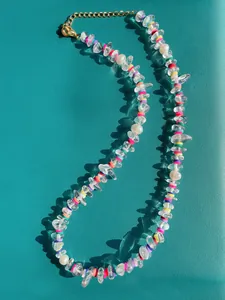 Dettaglio collana bohémien con pietre colorate irregolari e perline lucide