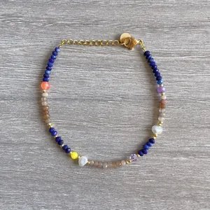 Detailed view of colorful natural stone beads and pearls on an 18K gold plated bracelet