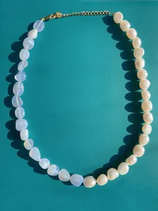 Dettaglio della collana boho con pietre blu irregolari e perle barocche bianche