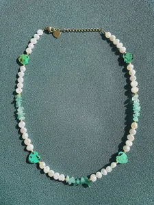 Dettaglio della collana bohémien con perle d'acqua dolce e perline a cuore verdi