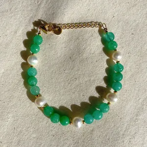 Detail of beaded bracelet with green stones, pearls and 18K gold plated clasp