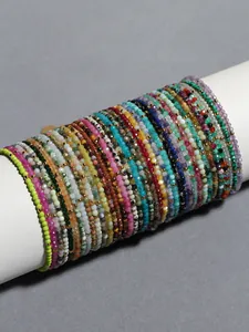 Détail de bracelets superposés en perles de pierre naturelle avec séparateurs dorés