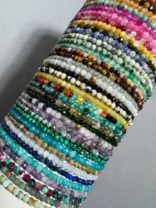 Macro view of stacked faceted natural stone beaded bracelets in assorted colors