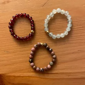 Detail view of handmade beaded elastic rings with natural gemstones and gold accents