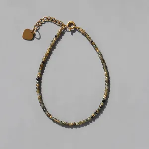 Détail de perles en pierre naturelle à facettes avec touches dorées et cœur