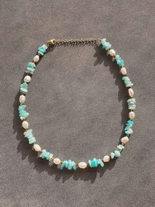 Dettaglio della collana boho con pietre blu, perle e chiusura a moschettone in metallo dorato