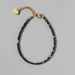 Detail of beaded natural stone bracelet with 18k gold plated chain and heart pendant