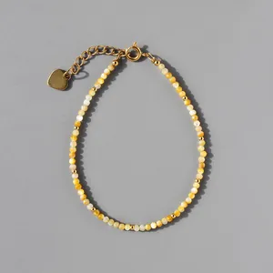 Détail d'un bracelet de perles bohème en pierres colorées avec breloque coeur dorée