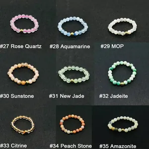 Detailed grid of nine natural stone beaded elastic rings with central gold accent bead