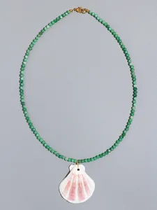 Close-up of green beaded necklace with natural shell pendant and gold lobster clasp detail