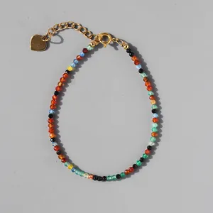 Close-up of colorful faceted stone beads bracelet with a gold heart charm and extender