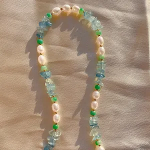 Collana boho con perline di pietre miste e perle d'acqua dolce su sfondo in seta