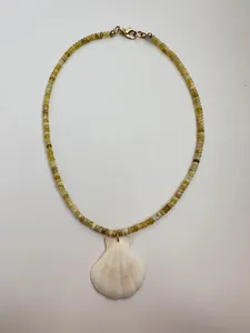 Detail of natural stone beaded necklace with white shell pendant and gold lobster clasp