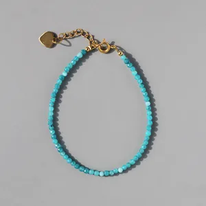 Detail of 2mm blue natural stone beads with 18k gold plated heart charm and clasp