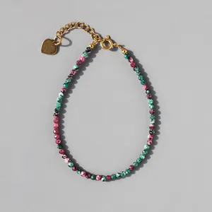 Detail of colorful stone beaded bracelet with gold heart charm and adjustable chain