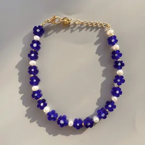 Dettaglio di perline in pietra naturale e petali blu con chiusura a moschettone dorata