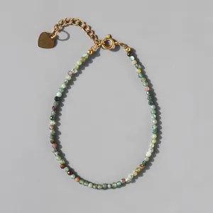 Detailed view of colorful natural stone beads and 18k gold plated heart charm bracelet