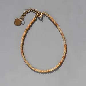 Détail du bracelet en perles d'ambre facettées avec breloque cœur doré et extension