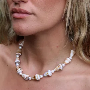 Dettaglio di una collana da spiaggia con conchiglie naturali e perle sul collo