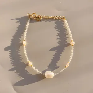 Dettaglio di perle barocche e perline sfaccettate con chiusura a moschettone dorata