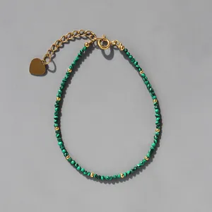 Gros plan du bracelet bohème en pierres vertes avec breloque cœur doré et chaîne d'extension
