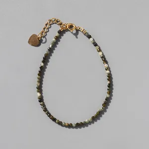 Detail of multi-colored faceted stone beads with 18k gold lobster clasp and heart charm