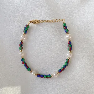 Vista dettagliata di perle in pietra naturale colorata e perle barocche sul bracciale