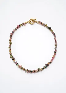 Détail macro des perles en pierre naturelle et fermoir à bascule doré du collier