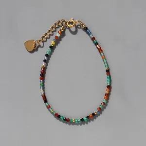 Détail du bracelet en pierres colorées à facettes avec breloque cœur et fermoir homard