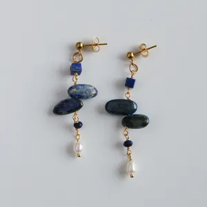 Detailed shot of handmade lapis lazuli drop earrings with pearls and gold wire