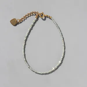 Detail of faceted blue beaded bracelet with gold heart charm and lobster clasp