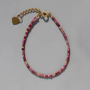 Vue détaillée d'un bracelet en pierres naturelles avec pendentif en cœur doré poli