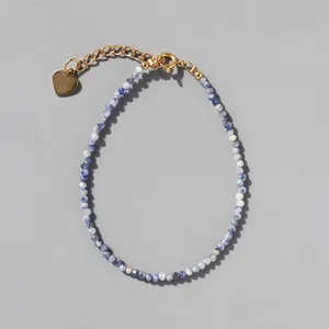 Detail of blue sodalite beaded bracelet with gold heart charm and adjustable chain