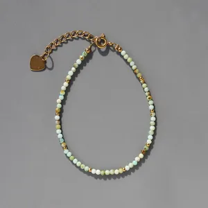 Détail de perles en pierres naturelles et breloque cœur dorée sur bracelet bohème
