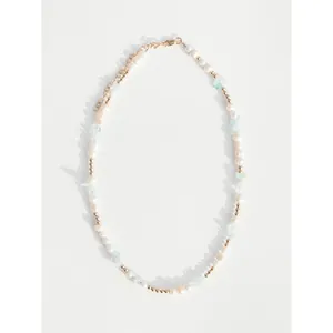 Collier en perles d'eau douce avec pierres bleu clair et perles dorées sur fond blanc