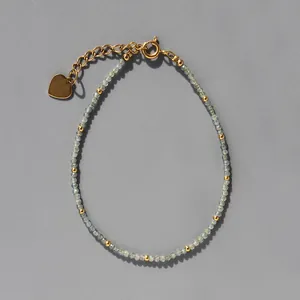 Détail du bracelet en pierres naturelles avec breloque cœur et fermoir doré