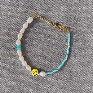 Bracciale fatto a mano con perle barocche, perline blu e ciondolo smiley giallo vivace