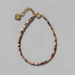 Detailed macro of colorful natural stone beads and gold heart pendant extension chain
