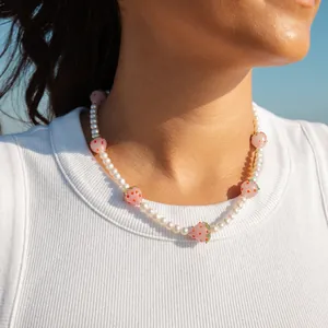 Collier de perles d'eau douce naturelles avec pendentifs fraises sur un mannequin