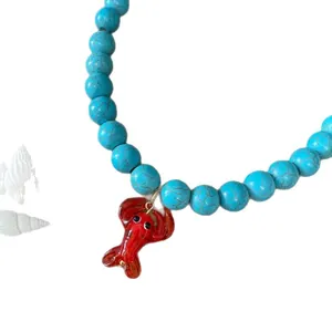 Collier en perles turquoise avec pendentif homard rouge et coquillages blancs