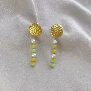 Detail of beaded drop earrings with gold hammered metal, pearls, and colorful glass beads