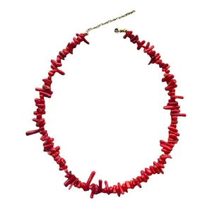 Dettaglio della collana di perline rosse con chiusura a moschettone dorata e catena