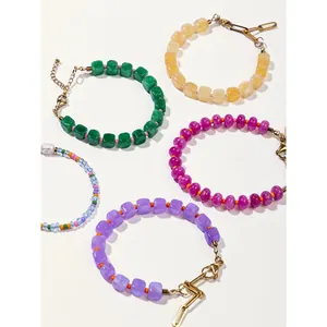 Lot de cinq bracelets en perles de pierre naturelle colorées avec fermoirs dorés et chaîne