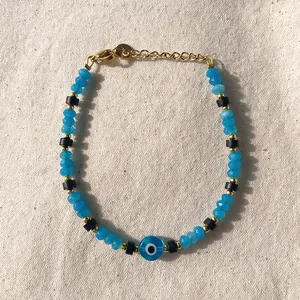 Dettaglio del bracciale con perline blu, ciondolo Evil Eye e chiusura dorata