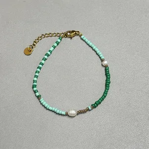 Detail of beaded bracelet with green and blue seed beads and natural freshwater pearls