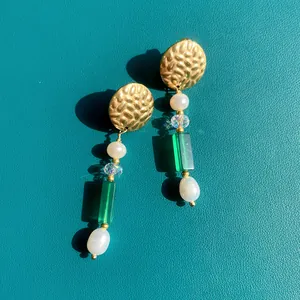 Detail of beaded earrings with natural stone, pearls and gold hammered metal disk